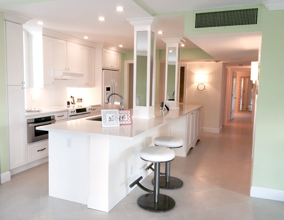 Foto di una grande cucina abitabile minimal con ante bianche, paraspruzzi bianco e elettrodomestici bianchi