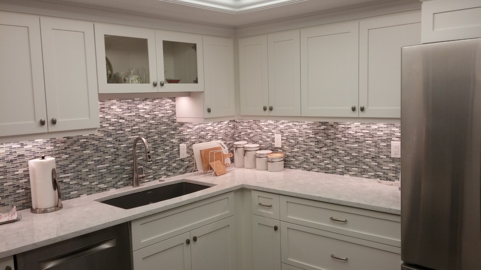 Kitchen - small transitional u-shaped ceramic tile kitchen idea in Miami with an undermount sink, shaker cabinets, white cabinets, quartz countertops, multicolored backsplash, stone tile backsplash, stainless steel appliances and no island