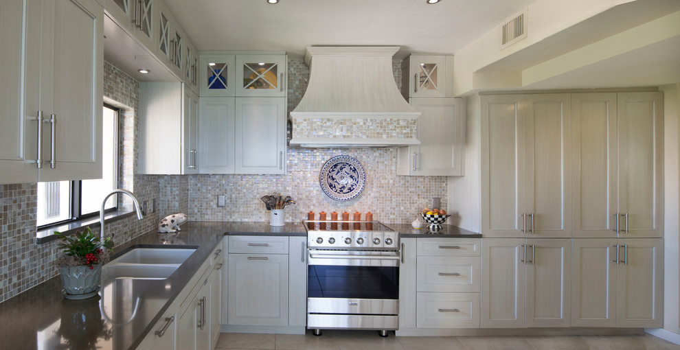 Inspiration for a medium sized classic u-shaped kitchen/diner in Miami with a built-in sink, shaker cabinets, engineered stone countertops, beige splashback, mosaic tiled splashback, integrated appliances, white cabinets, ceramic flooring, no island and beige floors.