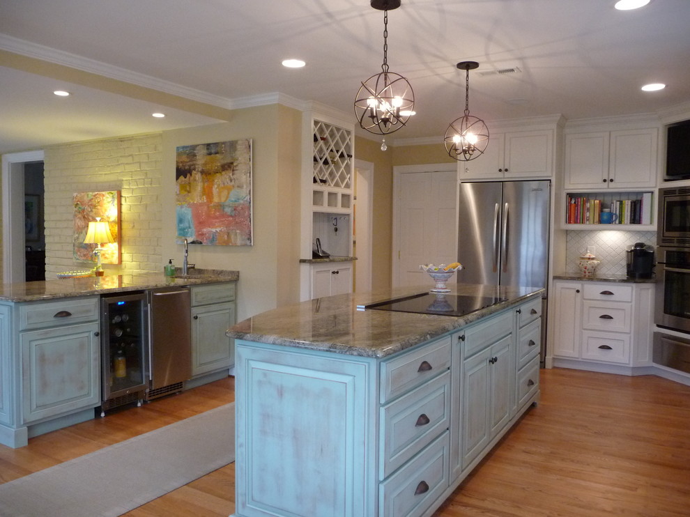 Ejemplo de cocina comedor clásica grande con electrodomésticos de acero inoxidable y suelo de madera clara