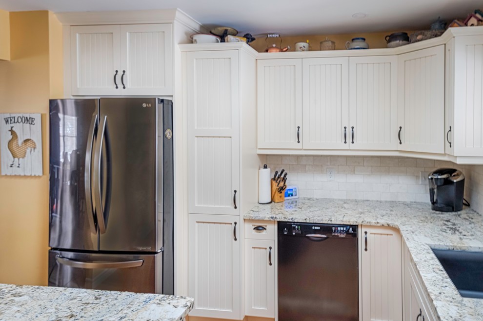 Exempel på ett avskilt, mellanstort lantligt beige beige l-kök, med en undermonterad diskho, skåp i shakerstil, vita skåp, granitbänkskiva, vitt stänkskydd, stänkskydd i tunnelbanekakel, rostfria vitvaror, mellanmörkt trägolv, en köksö och brunt golv