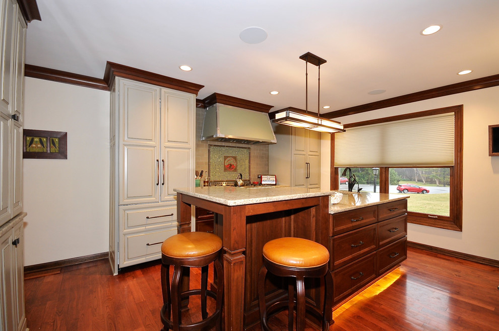 Example of a mid-sized arts and crafts single-wall medium tone wood floor eat-in kitchen design in Indianapolis with an undermount sink, recessed-panel cabinets, dark wood cabinets, granite countertops, multicolored backsplash, ceramic backsplash, white appliances and an island