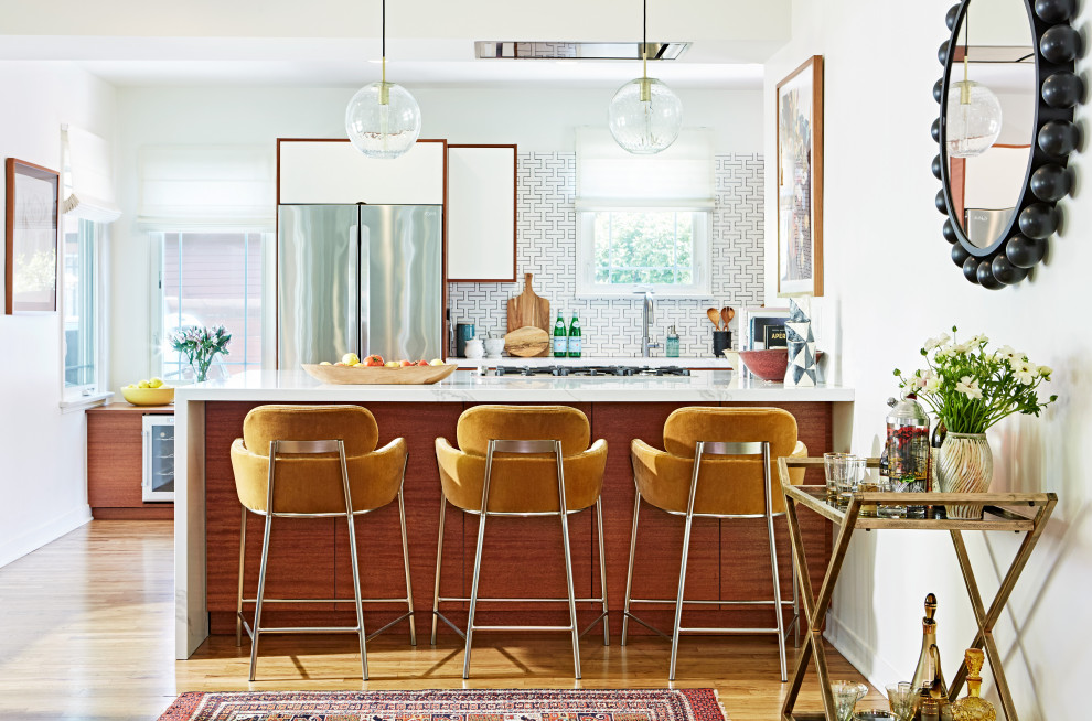 Small 1960s single-wall light wood floor and brown floor eat-in kitchen photo in Los Angeles with medium tone wood cabinets, white backsplash, ceramic backsplash, stainless steel appliances, an island and white countertops