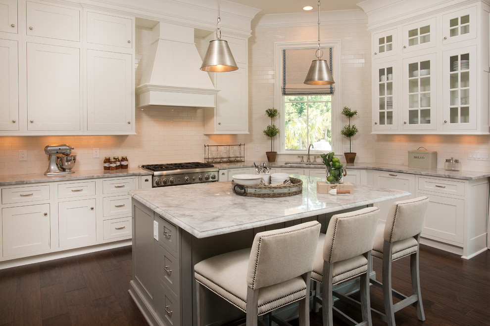 Design ideas for a beach style grey and white l-shaped kitchen in Atlanta with a submerged sink, shaker cabinets, white cabinets, white splashback, metro tiled splashback, stainless steel appliances, dark hardwood flooring and an island.