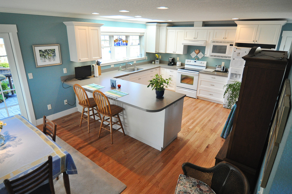 Classic u-shaped kitchen/diner in Seattle with a submerged sink, shaker cabinets, white cabinets and white appliances.