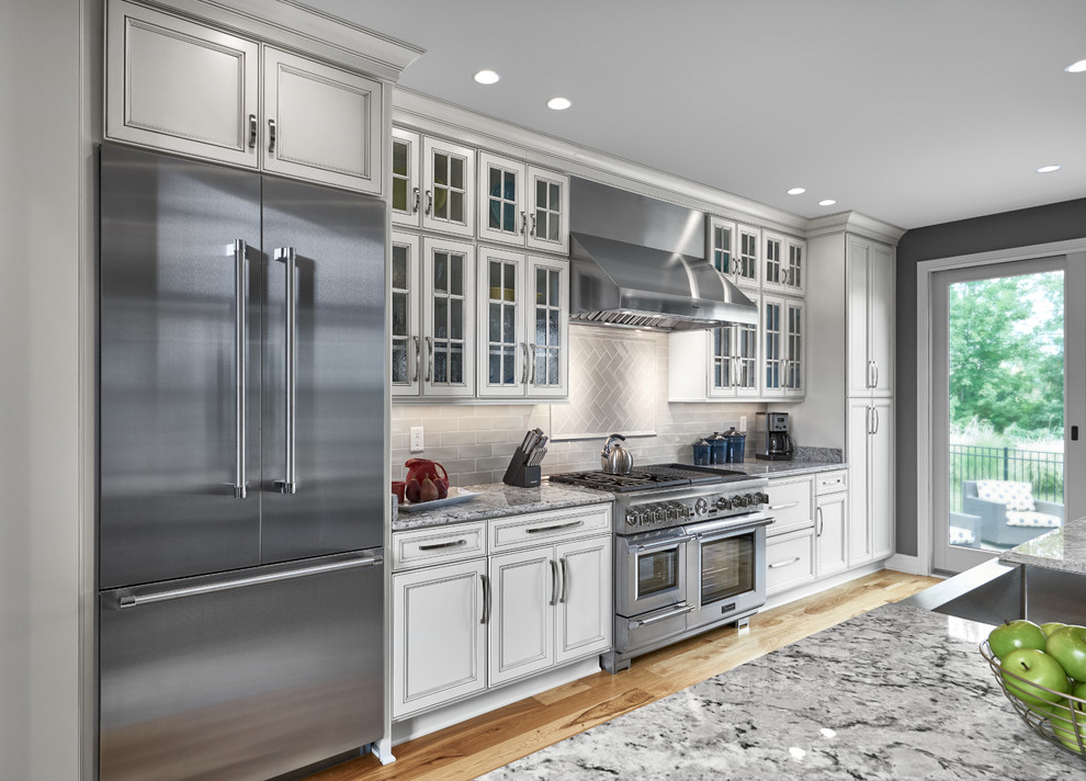 Inspiration for a large timeless galley light wood floor and brown floor enclosed kitchen remodel in Other with a farmhouse sink, recessed-panel cabinets, white cabinets, granite countertops, gray backsplash, stainless steel appliances, ceramic backsplash, no island and gray countertops