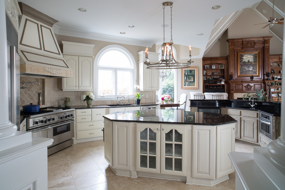 Design ideas for a large traditional u-shaped kitchen/diner in Atlanta with a submerged sink, raised-panel cabinets, white cabinets, granite worktops, beige splashback, stone tiled splashback, stainless steel appliances, ceramic flooring and multiple islands.