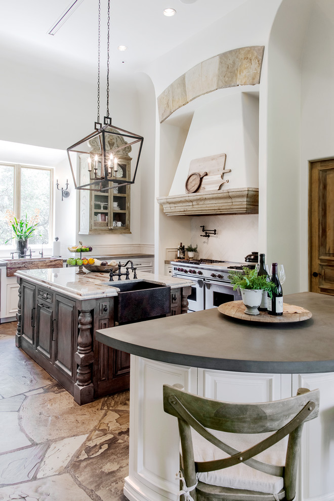 Foto på ett kök, med luckor med upphöjd panel, vita skåp, rostfria vitvaror och flera köksöar