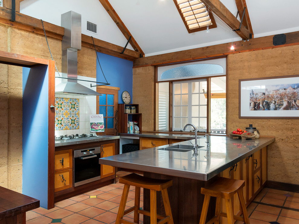 Exempel på ett medelhavsstil grå grått kök med öppen planlösning, med en integrerad diskho, släta luckor, bänkskiva i rostfritt stål, flerfärgad stänkskydd, rostfria vitvaror, klinkergolv i terrakotta, en halv köksö och rött golv