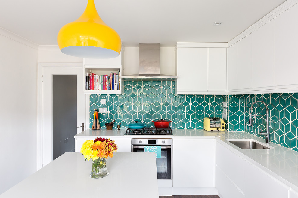 Mittelgroße Moderne Wohnküche in L-Form mit weißen Schränken, Küchenrückwand in Grün, Rückwand aus Keramikfliesen, Küchengeräten aus Edelstahl und Kücheninsel in London