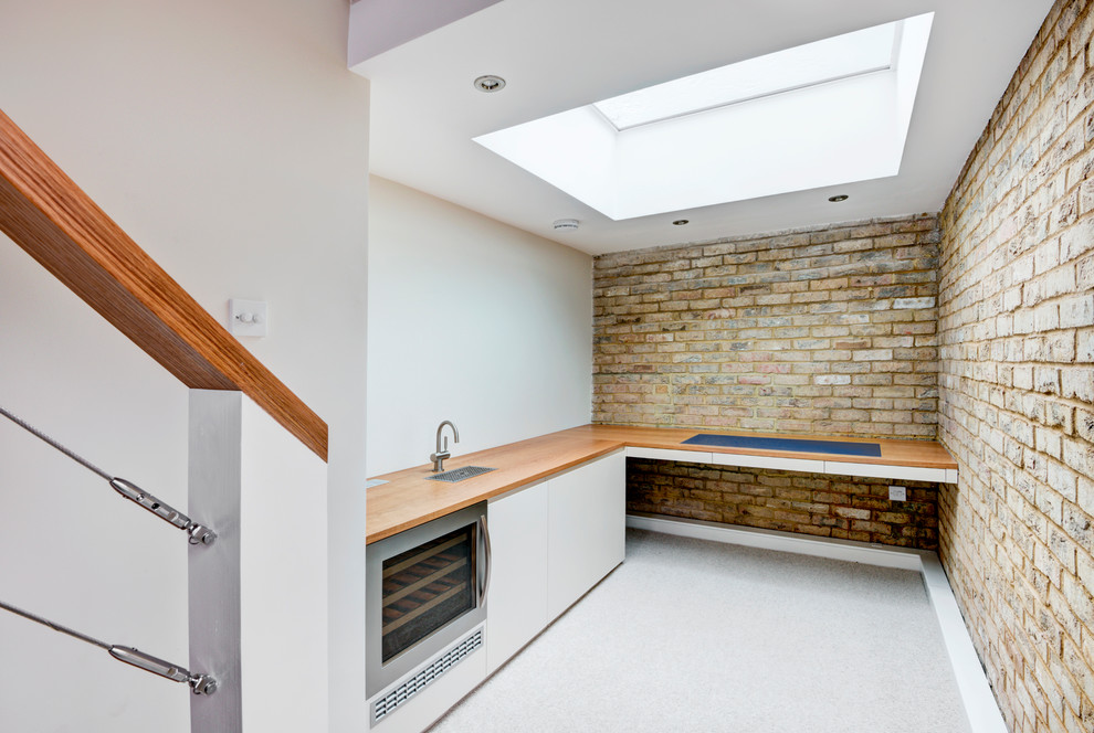 ロンドンにあるラグジュアリーな小さなコンテンポラリースタイルのおしゃれなキッチン (ドロップインシンク、フラットパネル扉のキャビネット、白いキャビネット、クオーツストーンカウンター、カーペット敷き、グレーの床) の写真