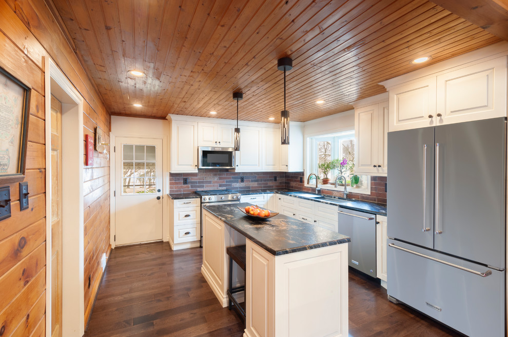 Large transitional l-shaped dark wood floor and brown floor eat-in kitchen photo in Philadelphia with an undermount sink, raised-panel cabinets, white cabinets, granite countertops, red backsplash, brick backsplash, stainless steel appliances, an island and black countertops