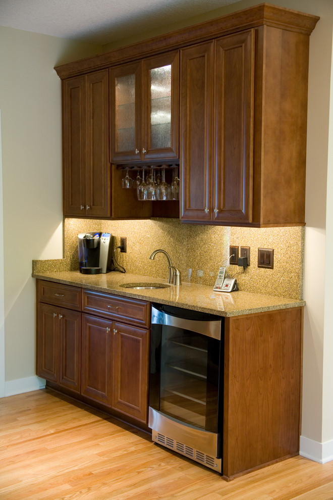 Photo of a medium sized traditional u-shaped kitchen/diner in Other with a submerged sink, recessed-panel cabinets, brown cabinets, brown splashback, stainless steel appliances, a breakfast bar and beige worktops.