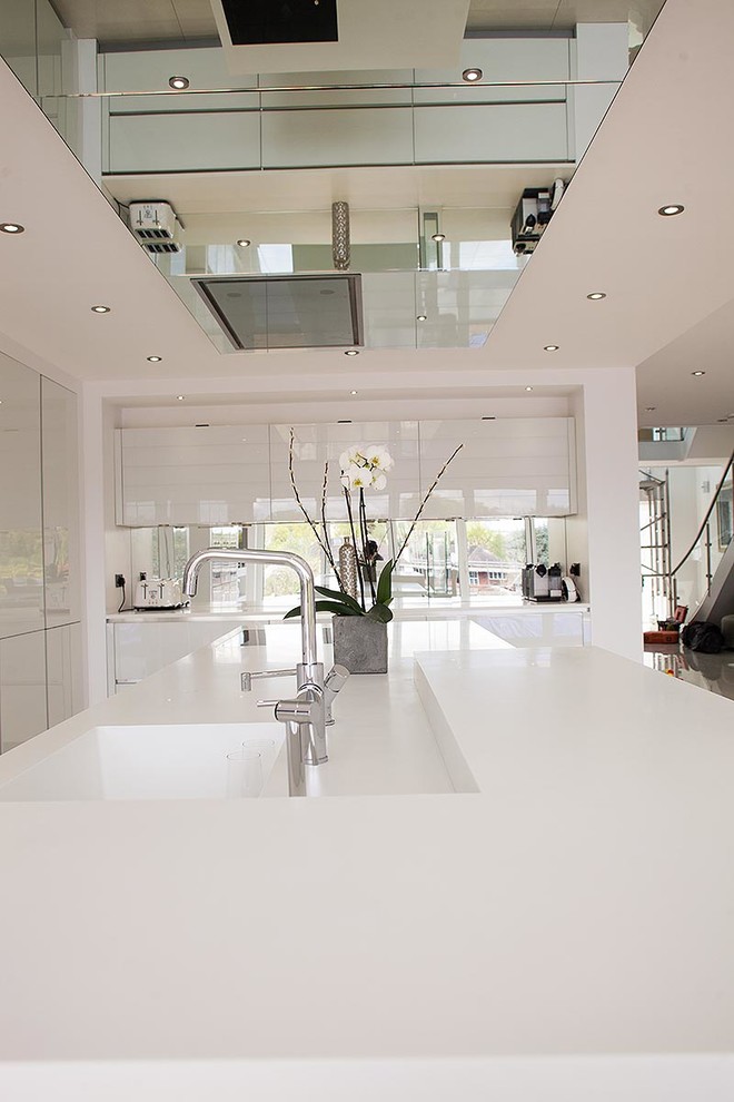 Diseño de cocina contemporánea grande con armarios con paneles lisos, puertas de armario blancas, electrodomésticos blancos, suelo de baldosas de porcelana y una isla