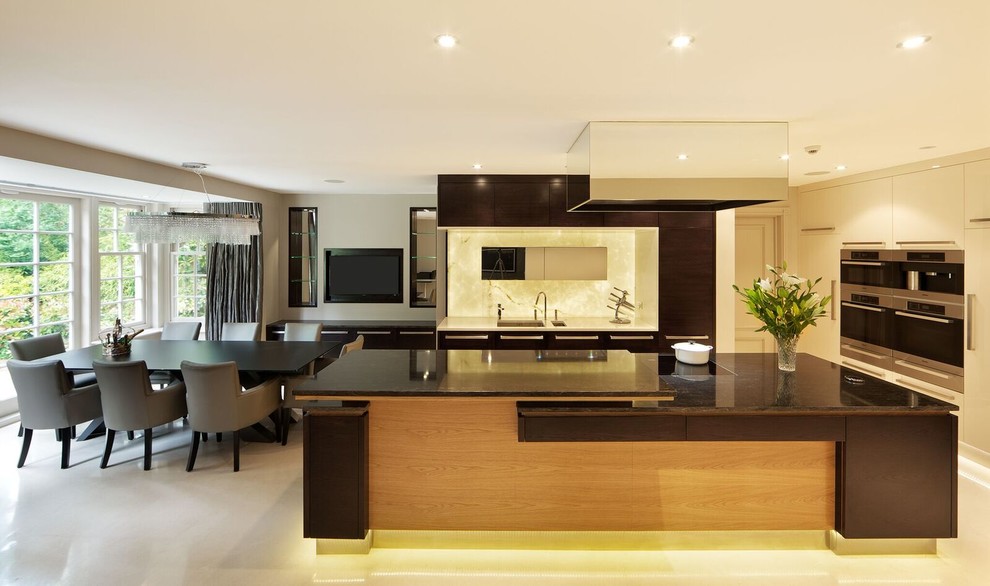 Large contemporary l-shaped kitchen/diner in Hertfordshire with a submerged sink, flat-panel cabinets, dark wood cabinets, marble worktops, white splashback, stainless steel appliances, porcelain flooring and a breakfast bar.
