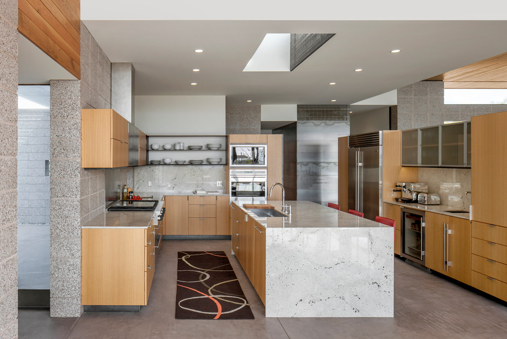 Идея дизайна: п-образная кухня-гостиная в стиле модернизм с плоскими фасадами, фасадами цвета дерева среднего тона и техникой из нержавеющей стали