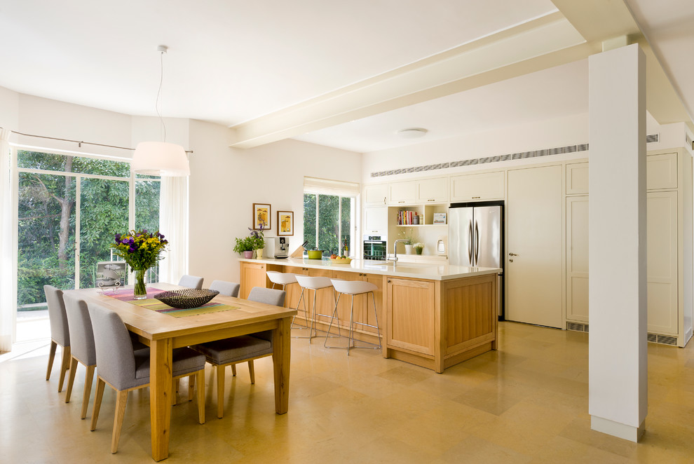 Imagen de cocina comedor contemporánea con electrodomésticos de acero inoxidable, armarios con paneles empotrados y puertas de armario beige