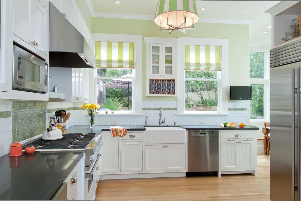 Example of a trendy kitchen design in San Francisco with a farmhouse sink, recessed-panel cabinets, white cabinets, quartz countertops and white appliances