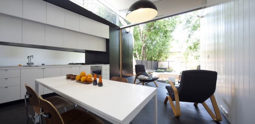 На фото: маленькая параллельная кухня в современном стиле с обеденным столом, плоскими фасадами и бетонным полом без острова для на участке и в саду