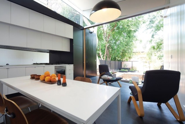 На фото: маленькая параллельная кухня в современном стиле с обеденным столом, плоскими фасадами и бетонным полом без острова для на участке и в саду с