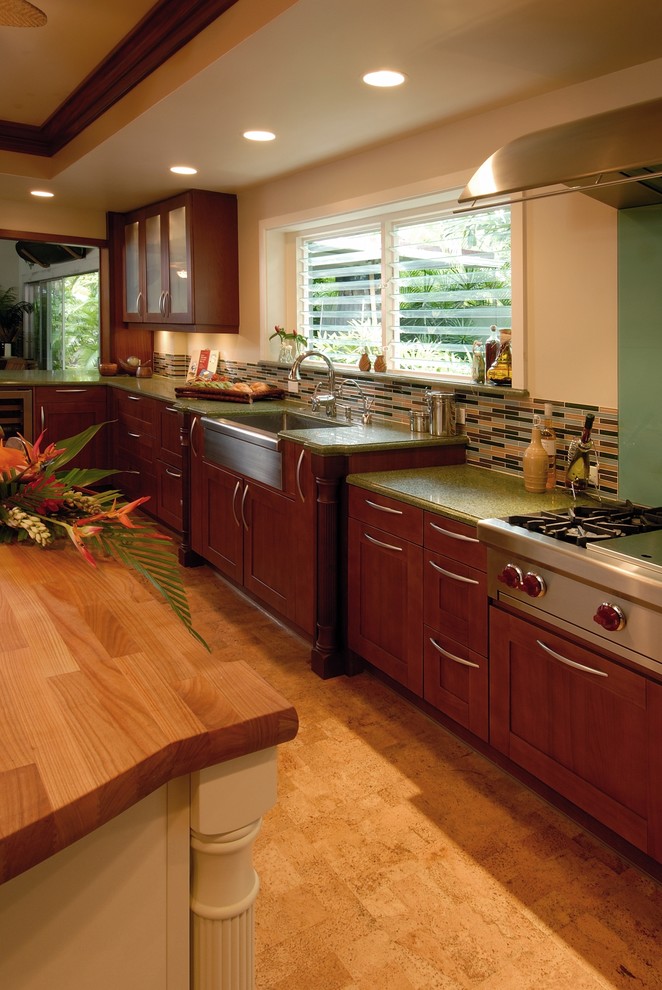 Exempel på ett exotiskt grön grönt kök och matrum, med en rustik diskho, träbänkskiva, stänkskydd i glaskakel, rostfria vitvaror, skåp i shakerstil, skåp i mellenmörkt trä, flerfärgad stänkskydd och korkgolv