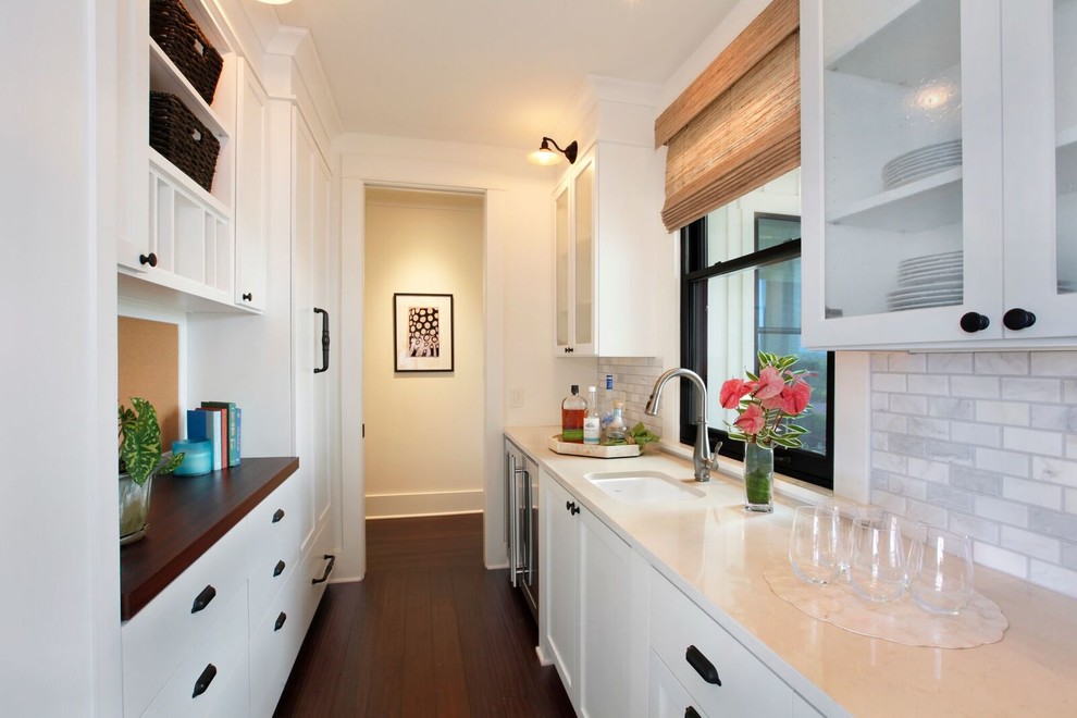 Foto på ett mellanstort kök, med en undermonterad diskho, skåp i shakerstil, vita skåp, marmorbänkskiva, vitt stänkskydd, stänkskydd i marmor, rostfria vitvaror, bambugolv och svart golv