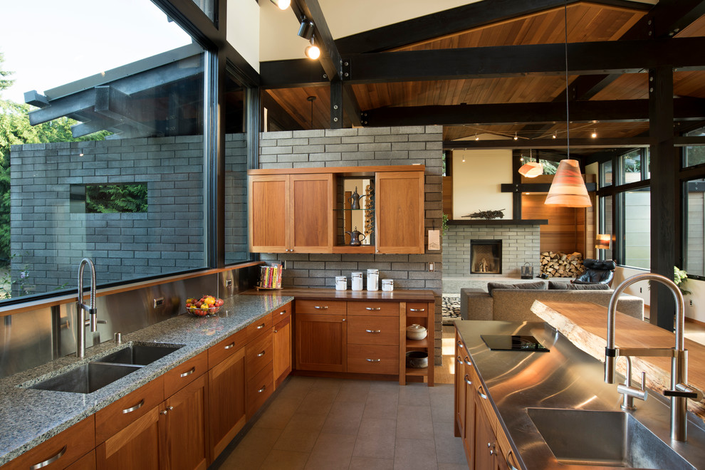 Modern inredning av ett stort kök, med skåp i mellenmörkt trä, en köksö, en undermonterad diskho, skåp i shakerstil, granitbänkskiva, grått stänkskydd, stänkskydd i tegel, rostfria vitvaror, klinkergolv i keramik och grått golv