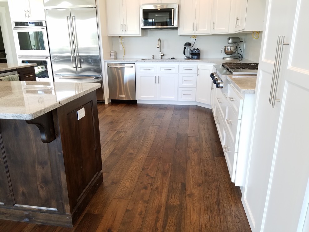 This is an example of a large contemporary kitchen in Boise with stainless steel appliances, medium hardwood flooring and an island.