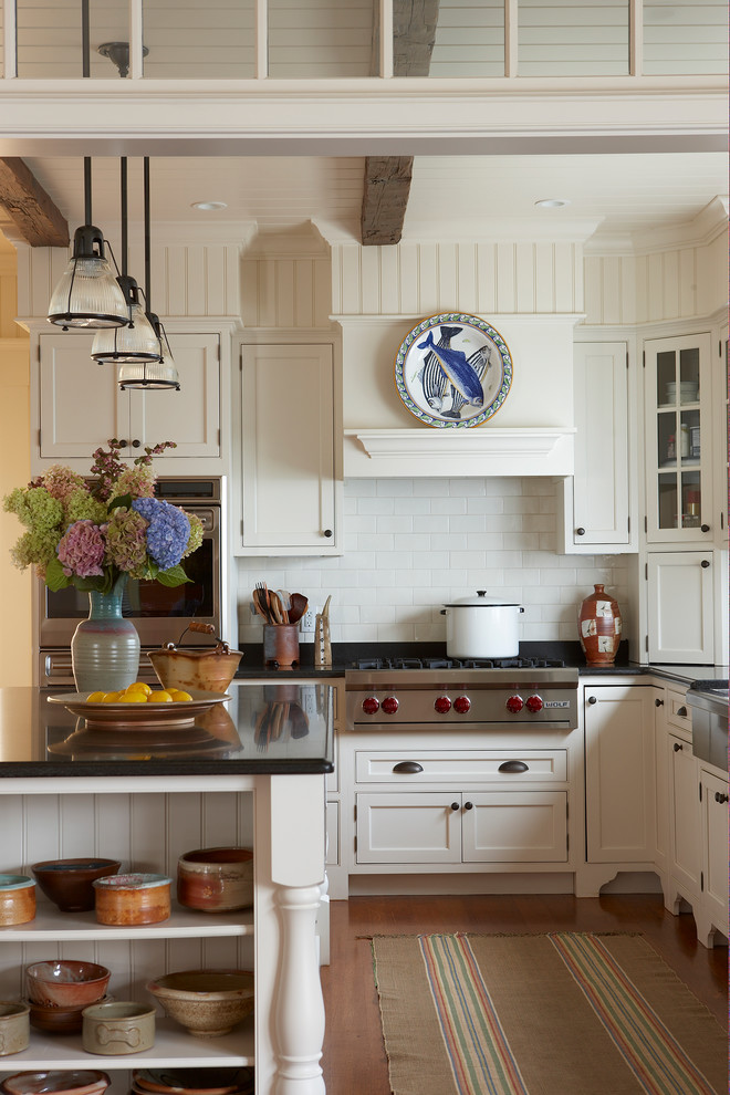 Design ideas for a traditional u-shaped kitchen/diner in Boston with stainless steel appliances, granite worktops, a belfast sink, recessed-panel cabinets, white cabinets, white splashback and metro tiled splashback.