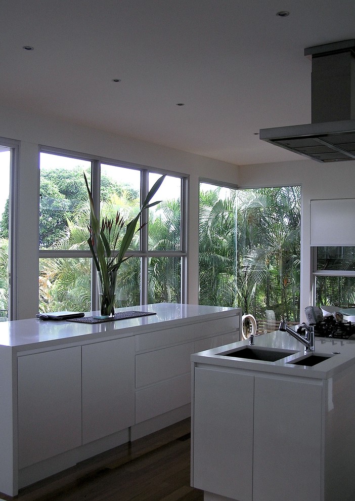 Exempel på ett modernt kök och matrum, med en undermonterad diskho, släta luckor, vita skåp, bänkskiva i kvarts och rostfria vitvaror