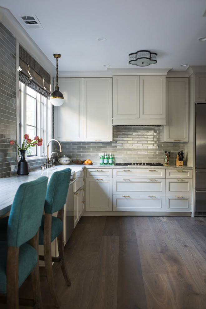 Example of a mid-sized eclectic l-shaped medium tone wood floor enclosed kitchen design in San Francisco with a farmhouse sink, shaker cabinets, gray cabinets, quartzite countertops, gray backsplash, ceramic backsplash, stainless steel appliances, no island and gray countertops