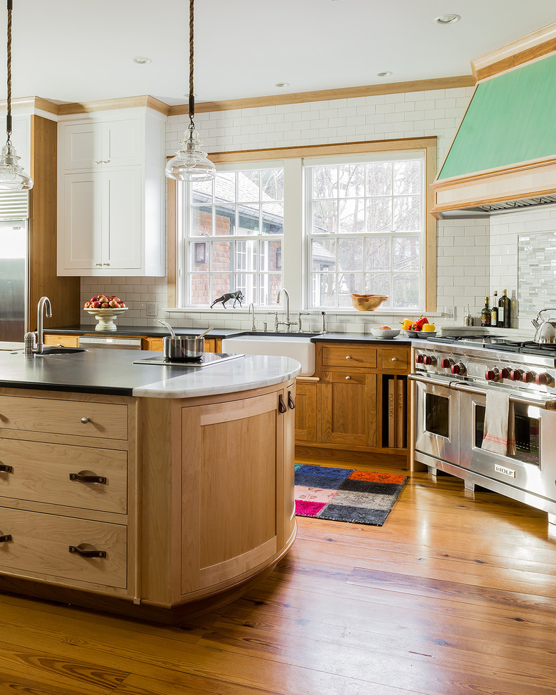 Große Klassische Küche in U-Form mit Landhausspüle, Schrankfronten im Shaker-Stil, hellen Holzschränken, Granit-Arbeitsplatte, Küchenrückwand in Weiß, Rückwand aus Metrofliesen, Küchengeräten aus Edelstahl, braunem Holzboden und Kücheninsel in Boston