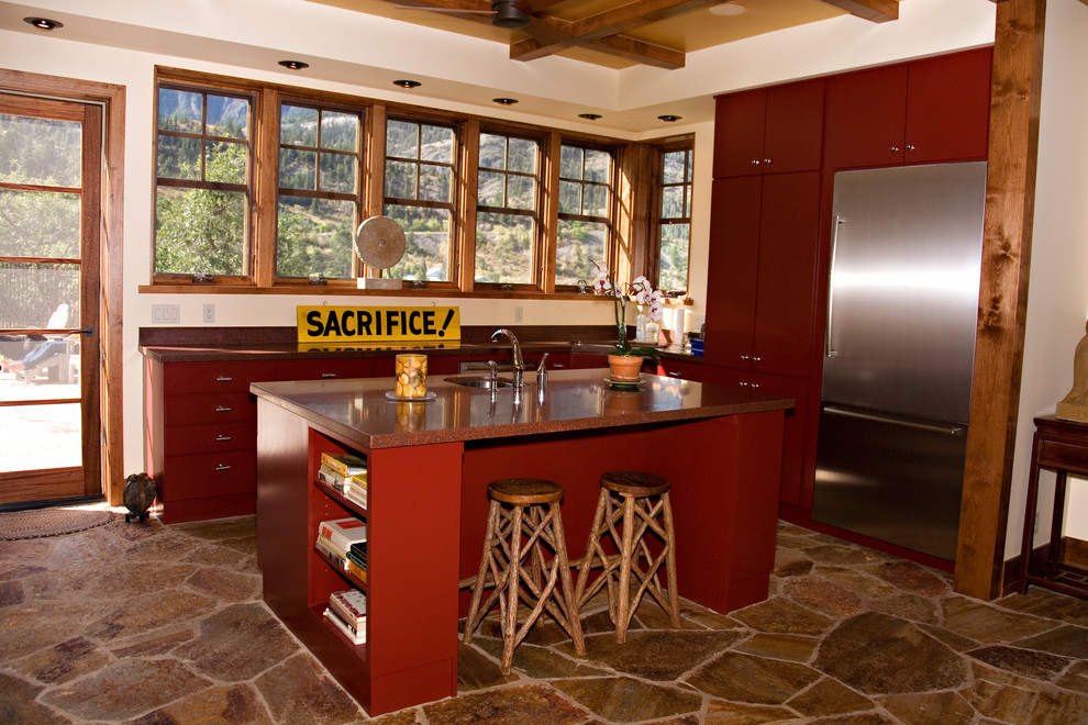 Inspiration for a medium sized rustic u-shaped open plan kitchen in Denver with a single-bowl sink, flat-panel cabinets, red cabinets, granite worktops, red splashback, stainless steel appliances, limestone flooring and an island.