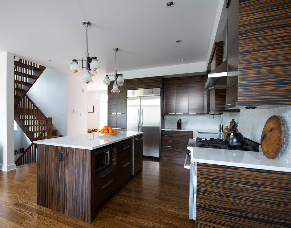 Immagine di una cucina a L minimalista con ante lisce, ante marroni, paraspruzzi bianco e elettrodomestici in acciaio inossidabile