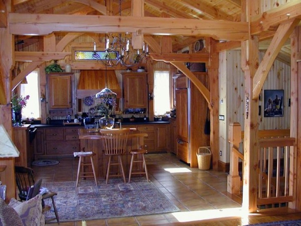 Esempio di una cucina stile rurale di medie dimensioni con ante con bugna sagomata, ante in legno scuro, top in granito, elettrodomestici da incasso e pavimento in gres porcellanato