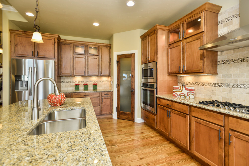 Elegant kitchen photo in Denver with recessed-panel cabinets and medium tone wood cabinets