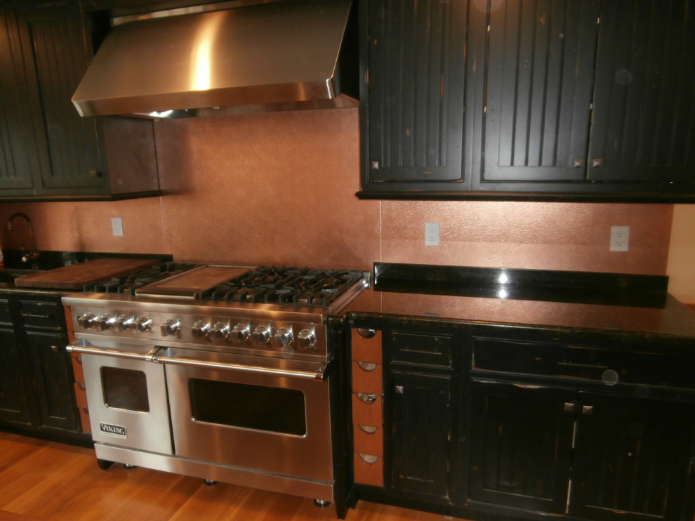 Exempel på ett stort klassiskt linjärt kök och matrum, med luckor med infälld panel, svarta skåp, stänkskydd i metallkakel, rostfria vitvaror och en köksö
