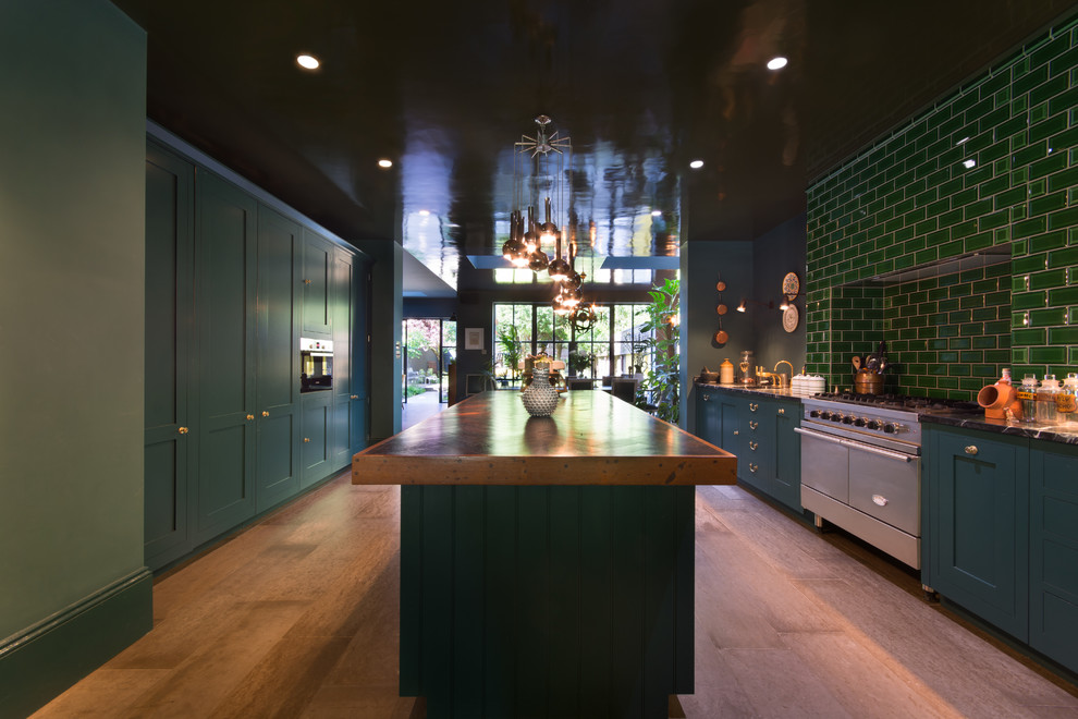 Design ideas for a large classic galley kitchen/diner in London with a submerged sink, shaker cabinets, blue cabinets, granite worktops, green splashback, metro tiled splashback, stainless steel appliances, medium hardwood flooring, an island, brown floors and black worktops.