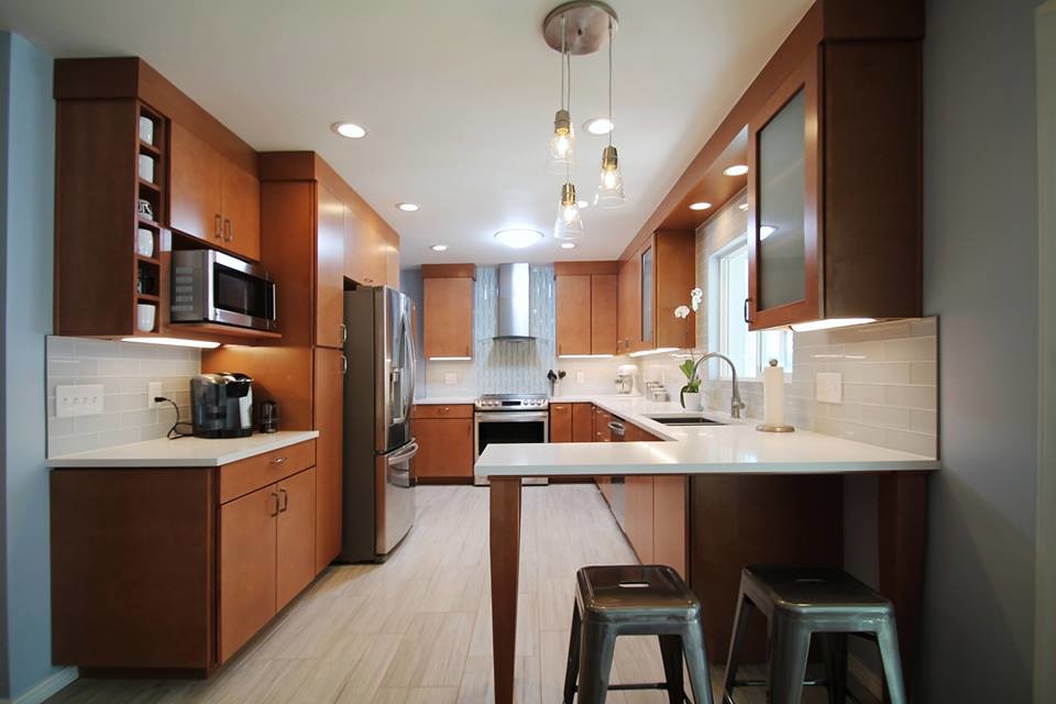 Eat-in kitchen - mid-sized transitional galley porcelain tile eat-in kitchen idea in Denver with an undermount sink, flat-panel cabinets, medium tone wood cabinets, quartz countertops, gray backsplash, glass tile backsplash, stainless steel appliances and a peninsula