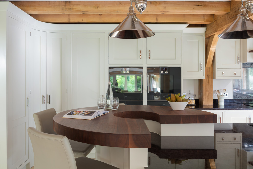 Foto di una cucina country con ante in stile shaker, ante grigie, top in granito, paraspruzzi a effetto metallico e elettrodomestici da incasso