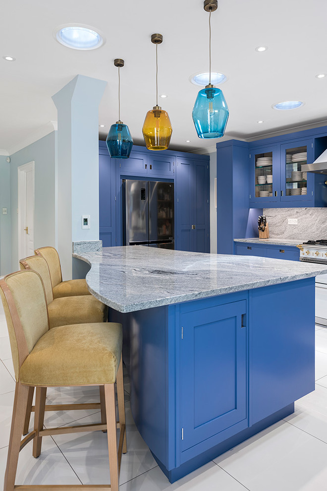 Design ideas for a medium sized contemporary l-shaped open plan kitchen in Hampshire with a built-in sink, shaker cabinets, blue cabinets, granite worktops, grey splashback, marble splashback, white appliances, ceramic flooring, an island, white floors and grey worktops.