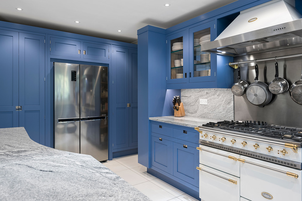 Inspiration for a medium sized contemporary l-shaped open plan kitchen in Hampshire with a built-in sink, shaker cabinets, blue cabinets, granite worktops, grey splashback, marble splashback, white appliances, ceramic flooring, an island, white floors and grey worktops.