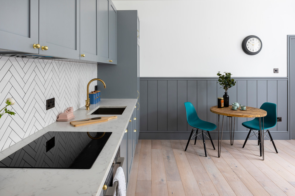Inspiration for a small traditional single-wall kitchen/diner in Hertfordshire with a submerged sink, shaker cabinets, grey cabinets, quartz worktops, white splashback, mosaic tiled splashback, black appliances, porcelain flooring, no island, grey floors and white worktops.