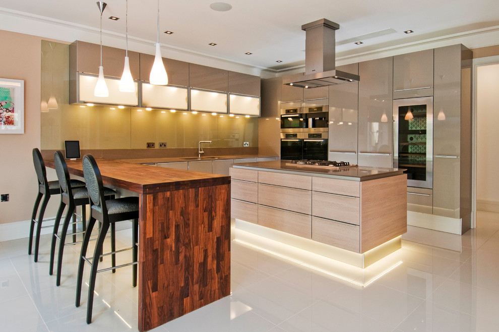 Moderne Küchenbar in U-Form mit flächenbündigen Schrankfronten, braunen Schränken, Küchenrückwand in Grün, Glasrückwand, Küchengeräten aus Edelstahl und Kücheninsel in London