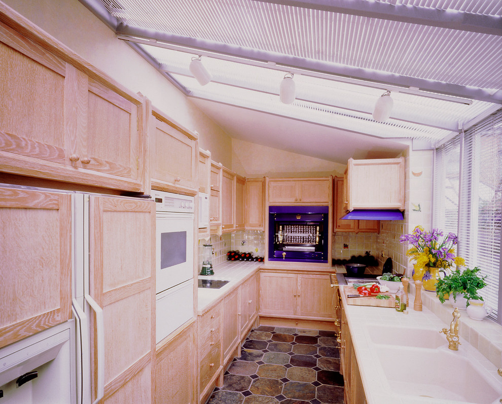 Пример оригинального дизайна: параллельная, отдельная кухня в классическом стиле с фасадами в стиле шейкер, светлыми деревянными фасадами, столешницей из плитки и цветной техникой