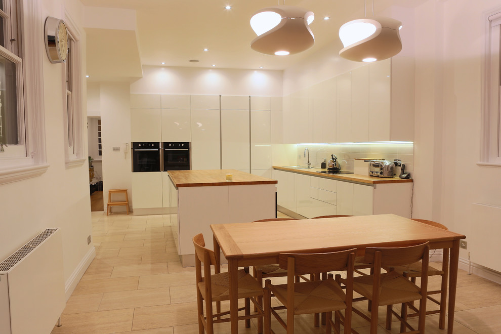 Mittelgroße Moderne Wohnküche in L-Form mit Waschbecken, Arbeitsplatte aus Holz, Rückwand aus Keramikfliesen, Küchengeräten aus Edelstahl, Keramikboden und Kücheninsel in London