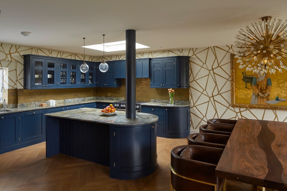 Пример оригинального дизайна: большая п-образная кухня-гостиная в стиле неоклассика (современная классика) с монолитной мойкой, фасадами с декоративным кантом, синими фасадами, гранитной столешницей, фартуком из каменной плитки, техникой из нержавеющей стали, паркетным полом среднего тона, островом, коричневым полом, серой столешницей и обоями на стенах