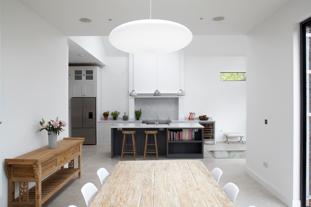 Design ideas for a medium sized classic open plan kitchen in London with a belfast sink, shaker cabinets, grey cabinets, marble worktops, marble splashback, stainless steel appliances, porcelain flooring and an island.