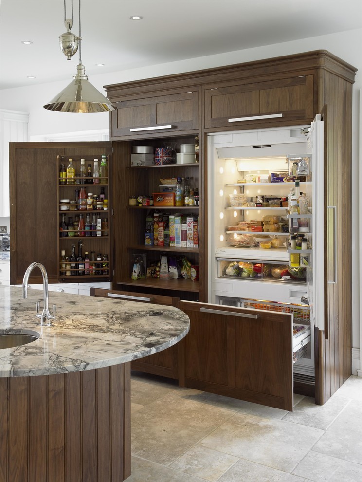 Kitchen pantry - transitional beige floor and limestone floor kitchen pantry idea in London with granite countertops, an undermount sink, shaker cabinets, dark wood cabinets, paneled appliances and an island