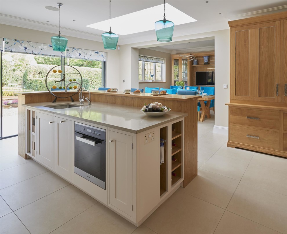 Example of a large transitional l-shaped eat-in kitchen design in Surrey with a single-bowl sink, shaker cabinets, quartzite countertops, stainless steel appliances and an island